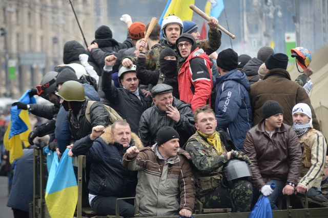 Pictured opposite, protestors celebrate after a compromise deal is reached between parliament and President Yanukovych.