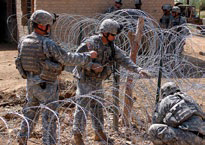 United States soldiers build a security fence in Muehla, Iraq.