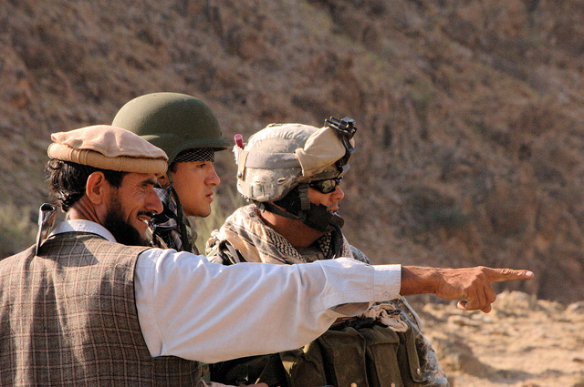 A US Army Sergeant receives road activity reports from a local and his interpretor in Nuristan Province, Afghanistan.