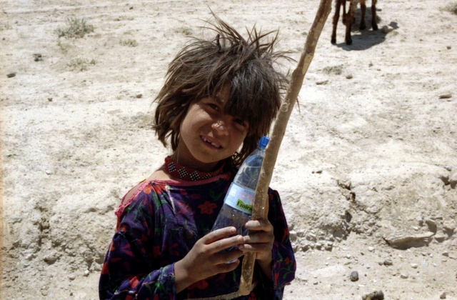 A Kuchi child holds a water bottle, something many of the remote villages of Afghanistan would not have access to otherwise.